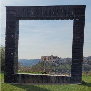 Schwarzer rechteckiger Rahmen mit Blick auf eine Burgruine in der Ferne.